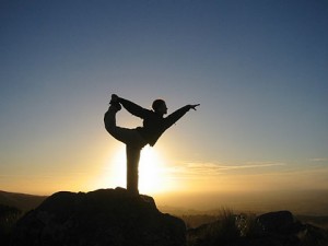 Man doing yoga on a mountain at sunrise