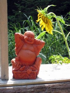 Red Buddha statue and sunflower | Rural Rootz, Ontario (by Shawn Radcliffe)